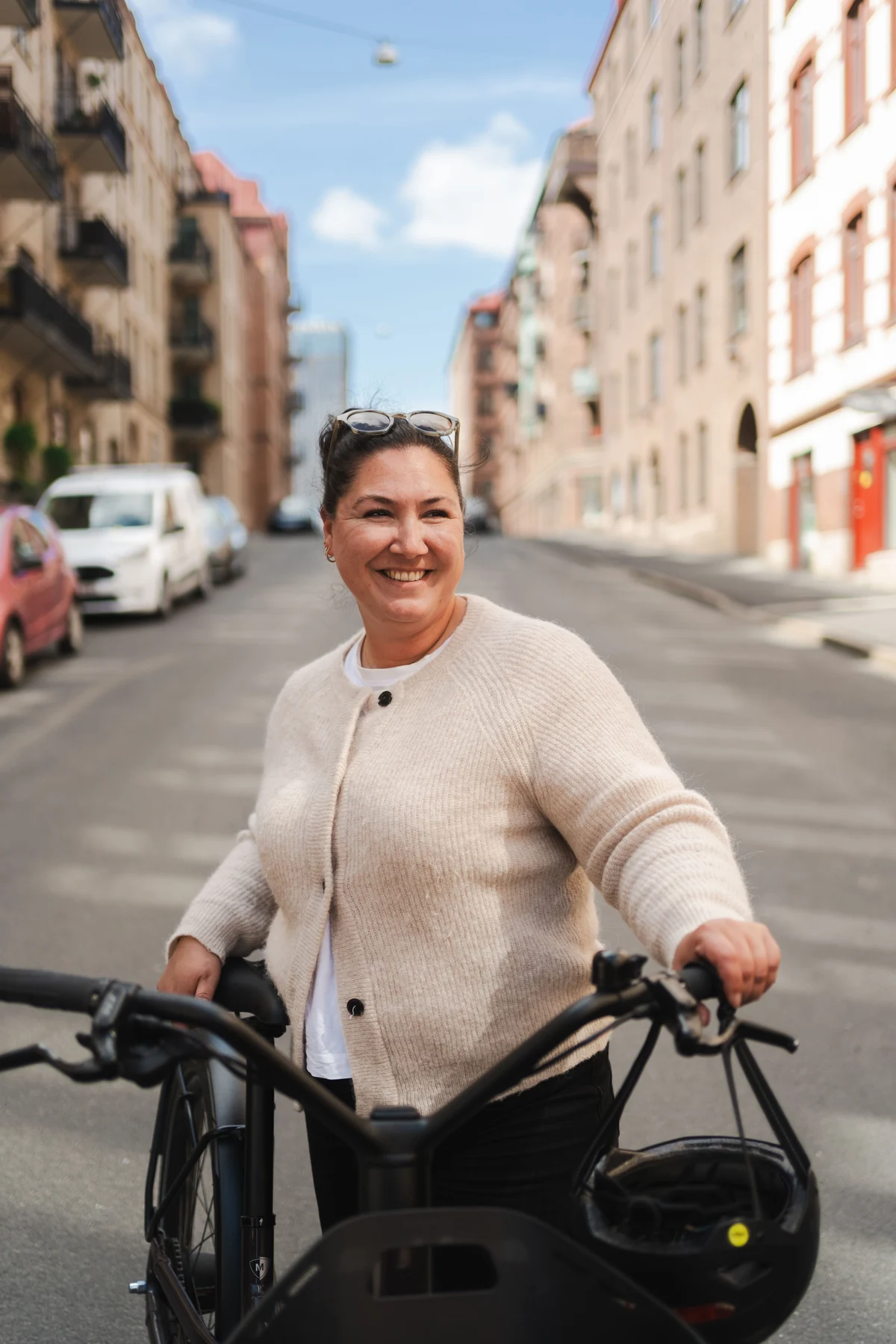 Mann steht mit Fahrrad vor Gebäude auf Platz